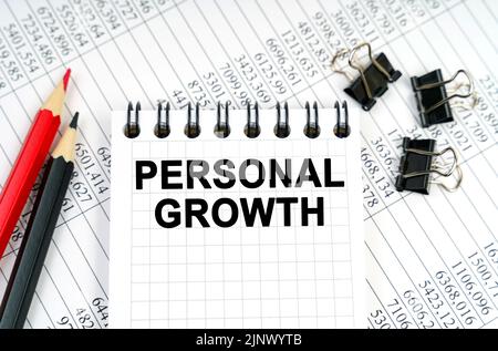 Economy and business concept. On the table are reports, pencils and a notebook with the inscription - PERSONAL GROWTH Stock Photo