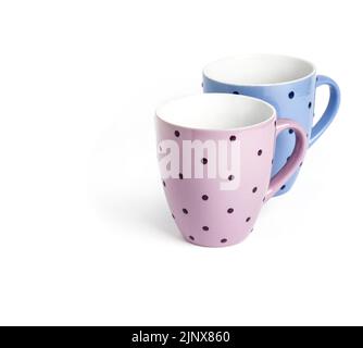 Pink and blue dotted mugs isolated on white background with clipping path. Copy space Stock Photo