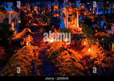 Tombs and graves are seen illuminated by burning candles during the Day of the Dead celebration at the cemetery in Xalpatláhuac, Guerrero, Mexico. Stock Photo