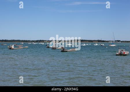 Boats for work on the oyster and mussel beds are moored on a calm sea. Stock Photo