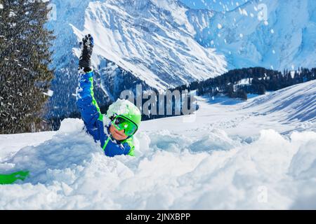 Fun with snow - happy boy play laying in snowdrift Stock Photo