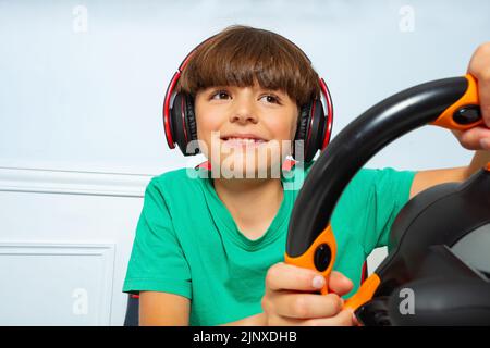 Close image with steering wheel of gamer young boy playing game Stock Photo