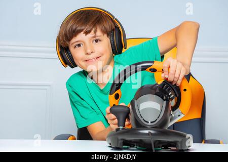 Engaged in race game child with headphones and steering wheel Stock Photo