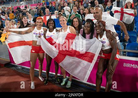 Jodie Williams, Ama Pipi, Jessie Knight and Victoria Ohuruogu of England celebrating with fans after competing in the women’s 4x400m final at the Comm Stock Photo