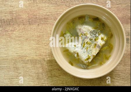 spicy bass fish head and tamarind leaf in Tom Yum soup on bowl Stock Photo