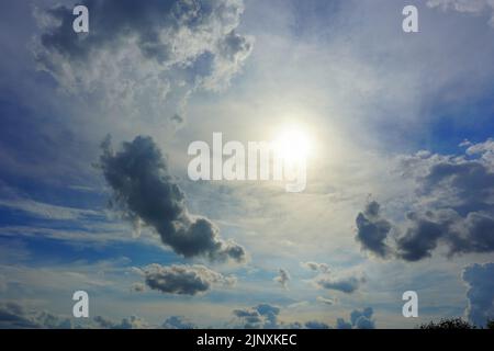 Hot sun shining through clouds. Stock Photo