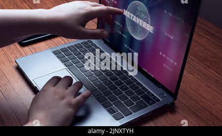 Woman touching laptop screen with metaverse hologram to log in. Technology and digital marketing. Digital link tech. Big data. Stock Photo