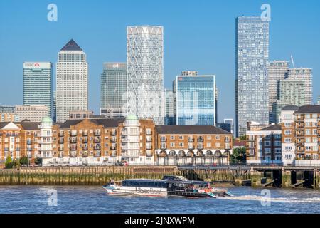 An Uber Boat by Thames Clippers passing the Rotherhithe Peninsula with Canary Wharf & the Isle of Dogs in the background. Stock Photo