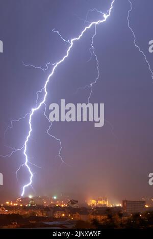 Storm Clouds and Lightning Bolts above the City Stock Photo