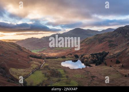 Epic aerial drone landscape image of sunrise from Blea Tarn in Lake District during stunning Autumn Stock Photo