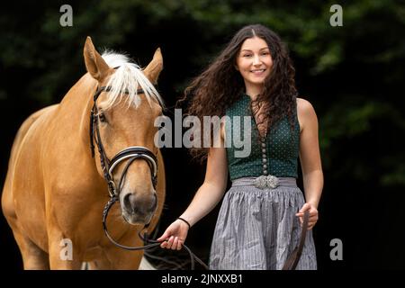 Portrait of a young woman cuddle with her horse. Equestrian and horse team scene Stock Photo