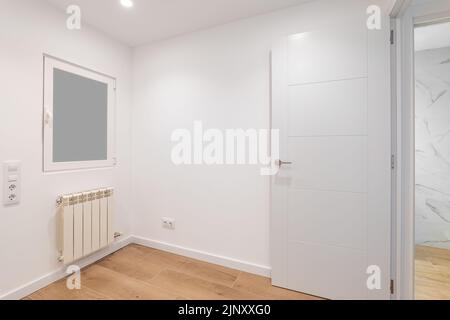 Empty room with frosted glass to avoid watching by neighbours. Laminate flooring and newly painted white walls in refurbished apartment. Stock Photo