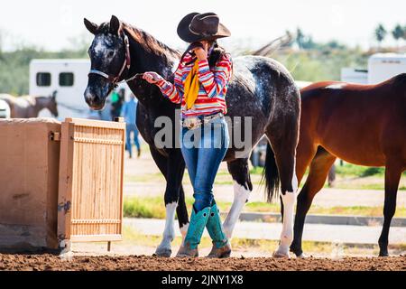 Female horse rider wearing western clothing ready to display her horse at a horse show in Phoenix, Arizona, USA Stock Photo