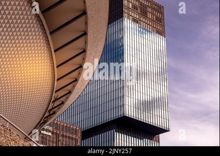 Katowice, Silesia, Poland; August, 7th, 2022: Spodek sports hall with KTW Business Park  glass walls in the warm sunlight reflected in the facades Stock Photo