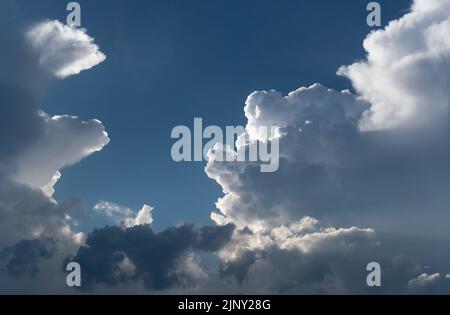 Big cloud in sky in dramatic sunlight close up, cloudscape panorama Stock Photo