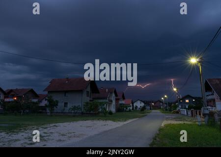 Thunderstorm and dark clouds above suburbs at dusk, bad weather Stock Photo