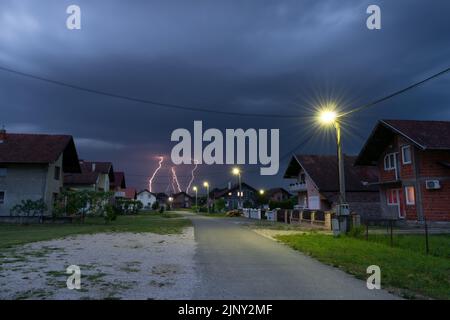 Thunderstorm and dark clouds above suburbs at dusk, bad weather Stock Photo