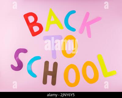 Inscription Back to school with colored letters on a pink background. Back to school concept Stock Photo