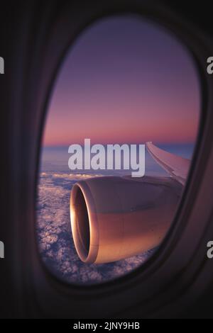 View from window of airplane during night flight above ocean. Selective focus on jet engine. Stock Photo