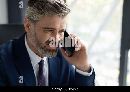 Closeup Portrait Of Handsome Middle Aged Businessman Making Phone Call In Office Stock Photo