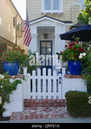 garden gate entry to traditional home with bright blue door Stock Photo