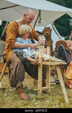 Hojbjerg, Denmark, August, 2022: Father carpenter teaching his son  Stock Photo