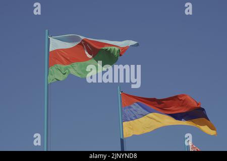The national flags of Azerbaijan and Armenia are fluttering in the wind. State symbols Stock Photo