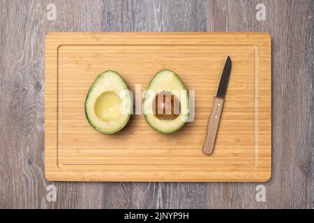 ripe haas avocados on a kitchen cutting board, top view, diet food, healthy food, vegan food product Stock Photo