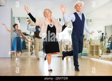Mature woman dancing swing with young man Stock Photo