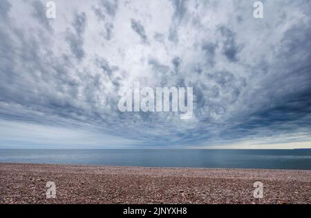 Wide angle (14mm at f/11) view of clouds over the sea horizon at Budleigh Salterton in East Devon on the Jurassic Coast (suitable for sky replacement) Stock Photo