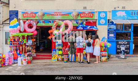 Ice cream parlour and roadside display of inflatables and beach toys in a shop by the Cobb, Lyme Regis on the Jurassic Coast in Dorset, south England Stock Photo