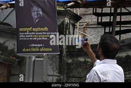 A man takes a photo of a poster paying tribute to the Indian ...