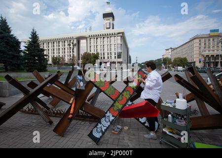 An artist paints anti-tank hedgehog barricades in central Kyiv. Stock Photo