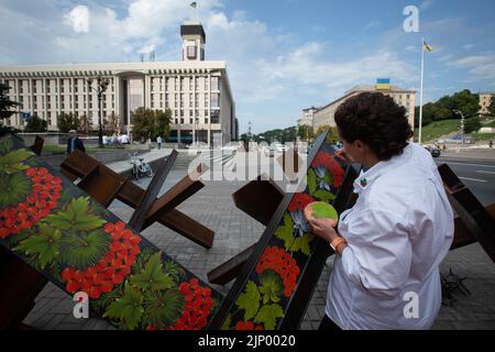 An artist paints anti-tank hedgehog barricades in central Kyiv. Stock Photo