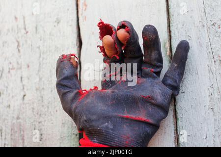 Defocus worn dirty and leaky gloves. Open palms of hands in worn workers gloves, protection against damage during operation, closeup on gray backgroun Stock Photo