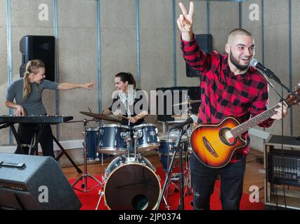 Bearded guy soloist playing guitar in studio Stock Photo