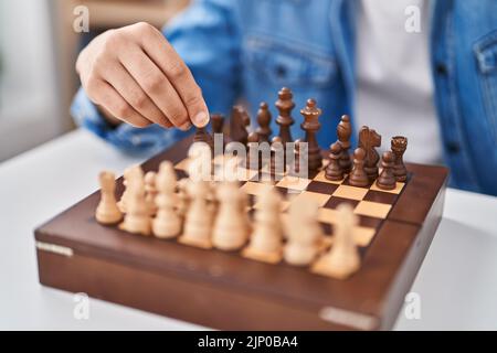 Young arab man playing chess sitting on table at home Stock Photo