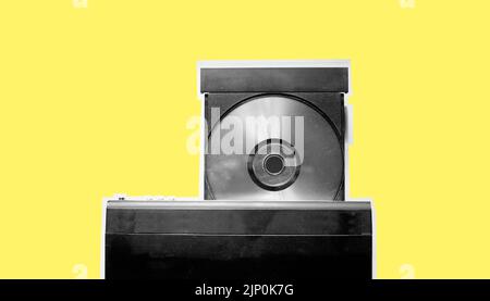Black and white of dirty dvd player with disk isolated on yellow pastel background Stock Photo