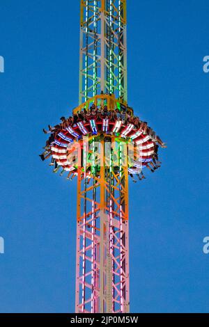 Herne, NRW, Germany. 14th Aug, 2022. People scream and laugh on the illuminated, 85m high 'Hangover - The Tower' thrill ride. Cranger Kirmes, Germany's 3rd largest funfair with a tradition dating back to the middle ages, has returned to pre-pandemic visitor numbers with more than 3.9m attending in hot, sunny weather, enjoying the rides, rollercoasters, beer halls, food and drink. The funfair concluded tonight with fireworks over the nearby Rhine-Herne Canal. Credit: Imageplotter/Alamy Live News Stock Photo