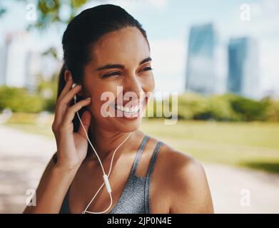 Shes found just the perfect soundtrack. an attractive young sportswoman listening to music while working out outdoors in the city. Stock Photo