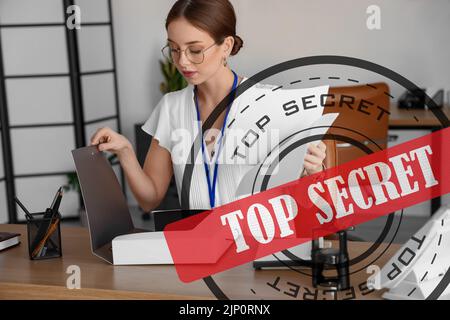 Woman working with top secret documents in office Stock Photo