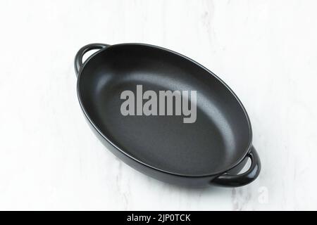 Empty Oval Black Dish on Marble Table Stock Photo