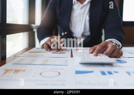 Asian Business Woman or Accountant do math and analyze with calculator ...