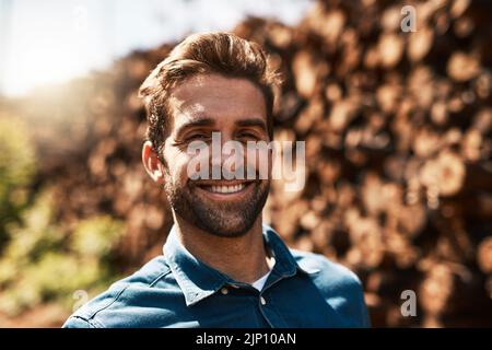 Ive got a love for lumber. Cropped portrait of a lumberjack standing in front of a pile of wood. Stock Photo
