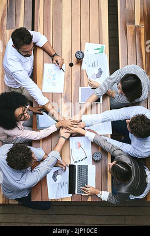 Equally contributing to a successful team. High angle shot of a team of businesspeople having a meeting outside. Stock Photo