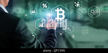 Man clicks on a virtual screen bitcoin icon Stock Photo