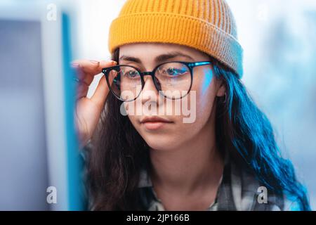 Investment, profitability and stock trading. Portrait of young trader wearing eyeglasses looking at trading charts at computer monitor, double exposur Stock Photo