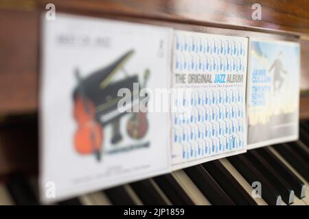 jazz cd's, various, variety, selection propped against piano keys of a piano with selective focus on the word jazz concept genres of music Stock Photo