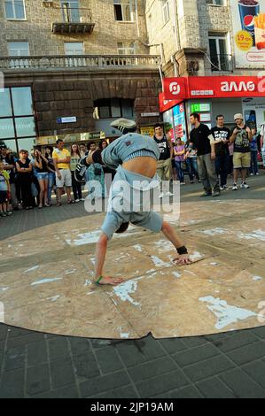Young boy dancing break dance on the street, crowd of people watching. July 12, 2018. Kyiv, Ukraine Stock Photo