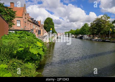 Brugge, Belgium - July 4, 2022: Old canal with trees and houses in Bruges Stock Photo